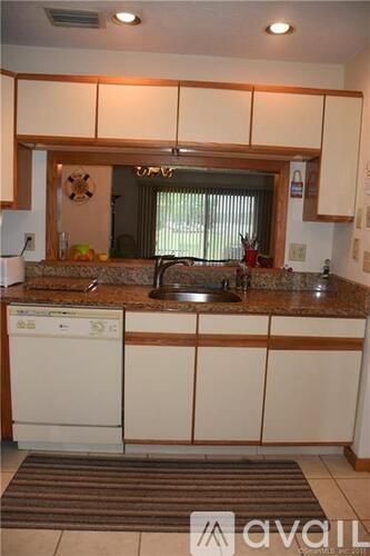 A kitchen with white cabinets and a granite countertop.