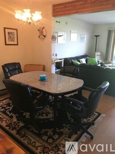 A dining room with a round table surrounded by chairs.
