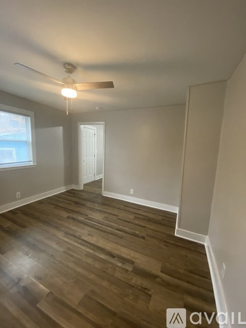 A room with wooden flooring and a ceiling fan.