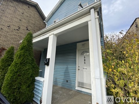 A blue house with a white door and a small porch.