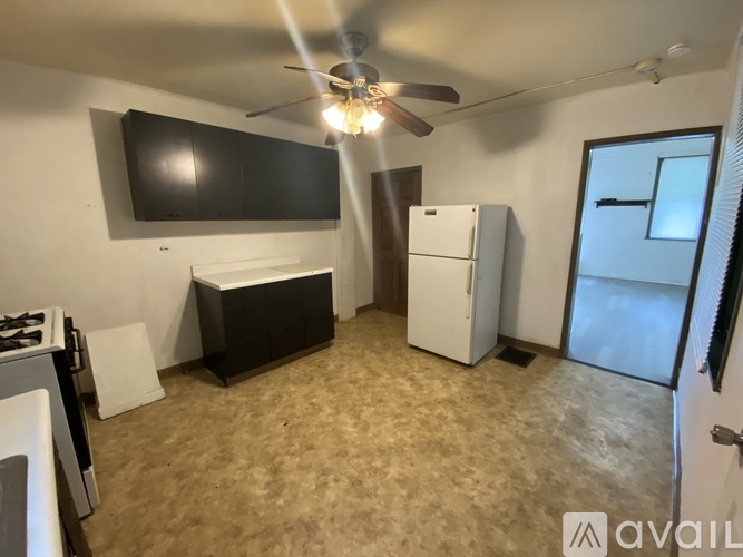 A kitchen with a black countertop and a white fridge.
