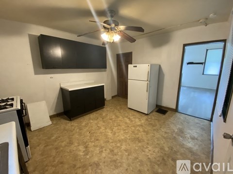 A kitchen with a black countertop and a white fridge.