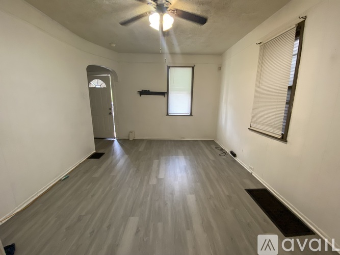 A room with a ceiling fan and a door on the left side.