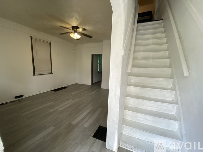 A room with a staircase leading to another room.