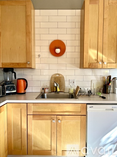 A kitchen with wooden cabinets and a white tiled backsplash.