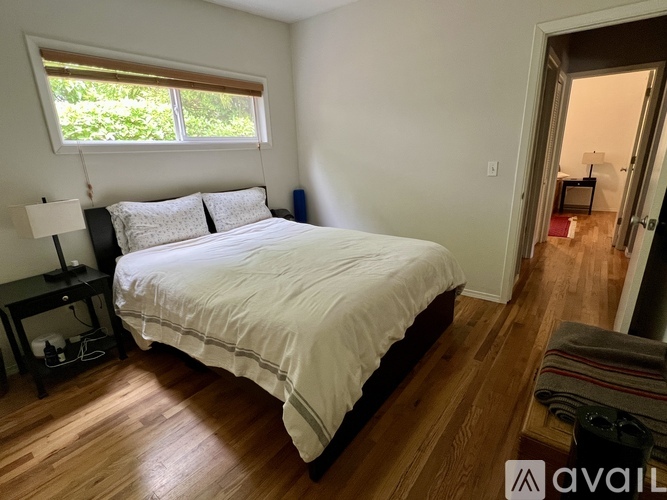 A bedroom with a large bed and a window.