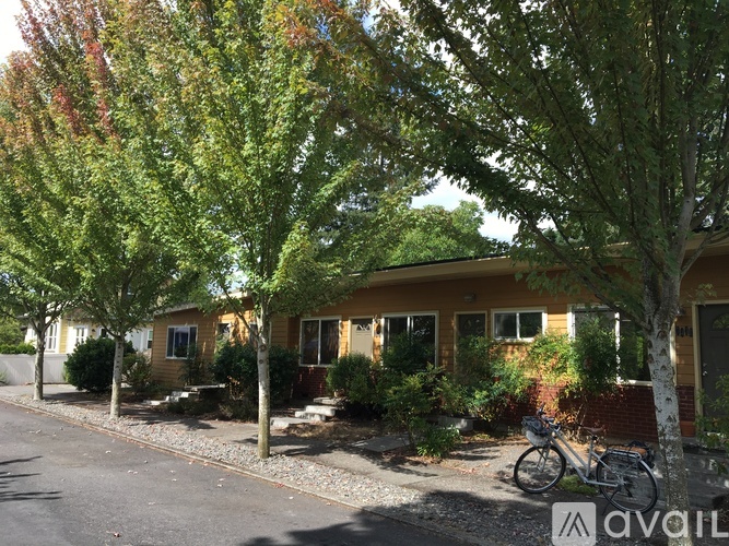 A row of houses with trees in front.