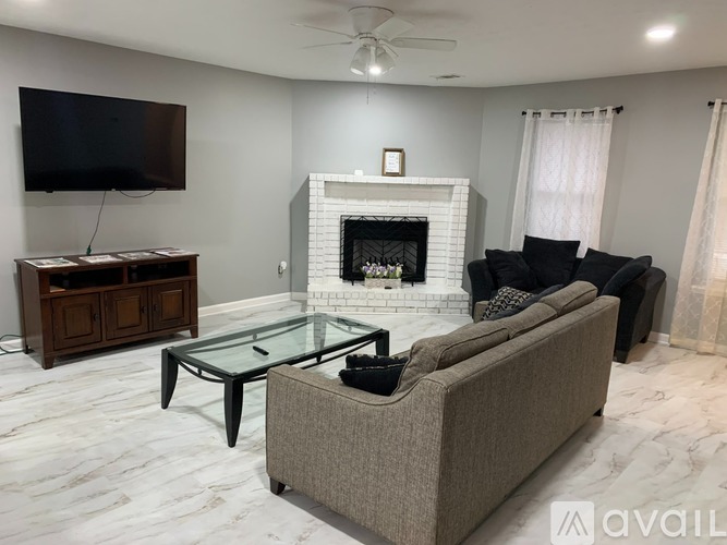 A living room with a fireplace, a couch, and a television.