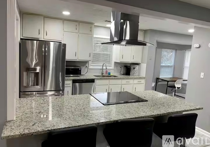 A modern kitchen with granite countertops and stainless steel appliances.