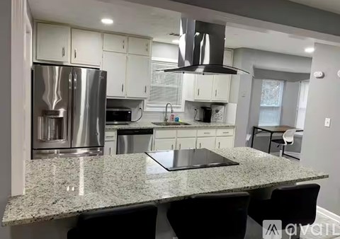 A modern kitchen with granite countertops and stainless steel appliances.