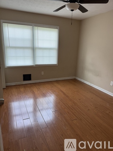 A room with wooden flooring and a ceiling fan.