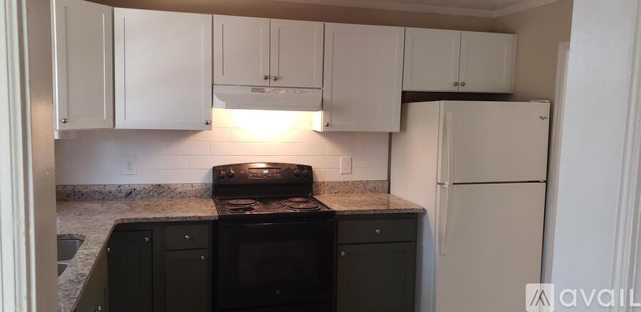 A kitchen with white cabinets and a black stove top oven.