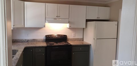 A kitchen with white cabinets and a black stove top oven.