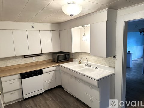 A kitchen with white cabinets and appliances.