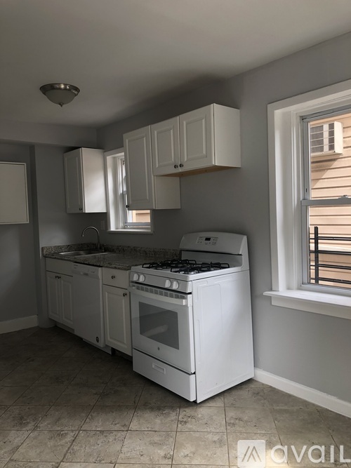A kitchen with white appliances and cabinets.