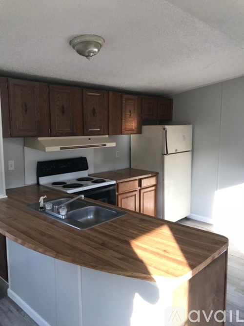 A kitchen with wooden cabinets and a white fridge.