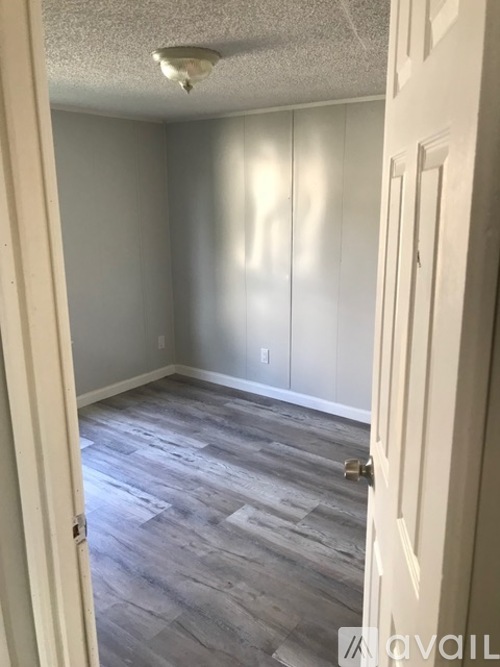 A room with a door and a wall with a switch.