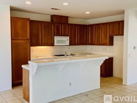 A kitchen with brown cabinets and a white island.