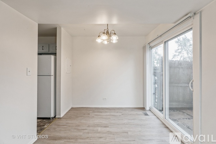 A room with a refrigerator and a window.