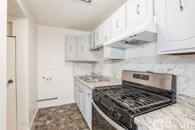 A kitchen with a black stove top oven and white cabinets.