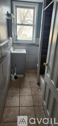 A bathroom with a toilet, sink, and a window.