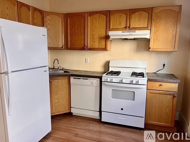 A kitchen with wooden cabinets and white appliances.
