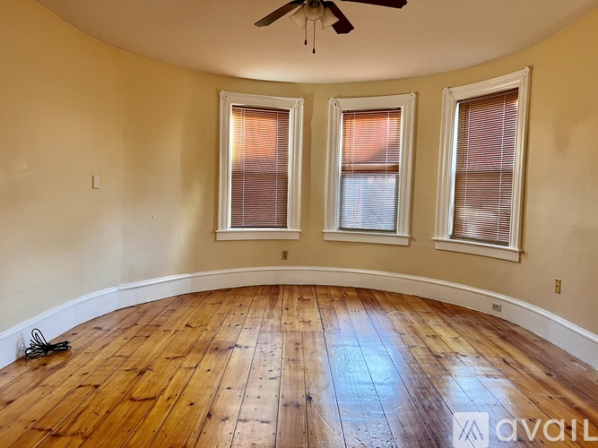 A room with wooden floors and a ceiling fan.