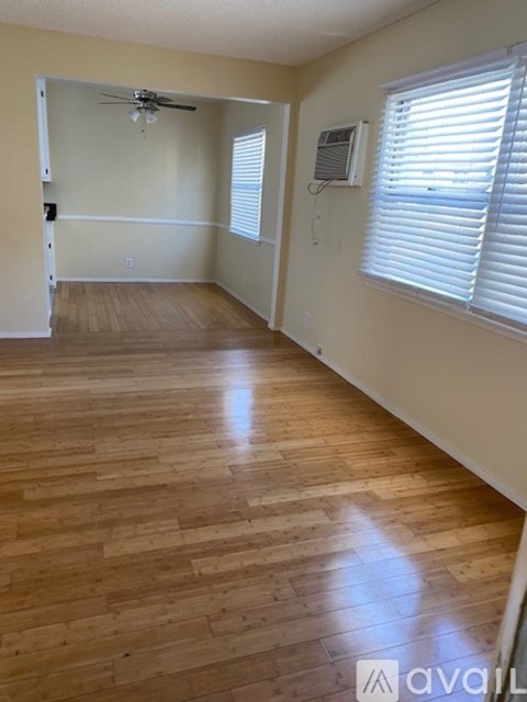 A room with wooden flooring and a ceiling fan.