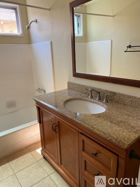 A bathroom with a sink, mirror, and bathtub.