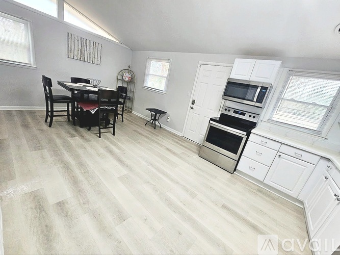 A kitchen with a dining table and chairs in the middle of the room.