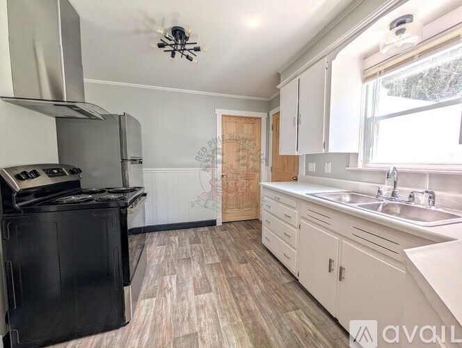 A kitchen with a black stove top oven and white cabinets.