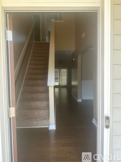 A hallway with a staircase leading to the second floor.