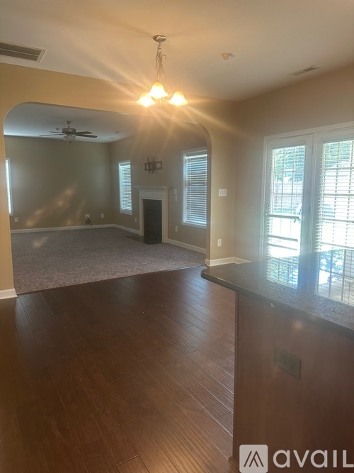 A spacious room with a ceiling fan and a window with blinds.