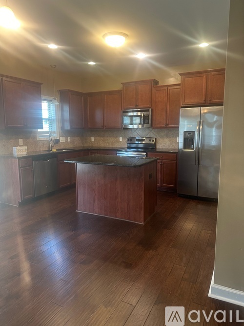 A kitchen with wooden cabinets and a stainless steel refrigerator.