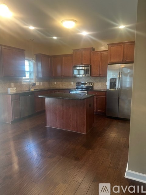 A kitchen with wooden cabinets and a stainless steel refrigerator.