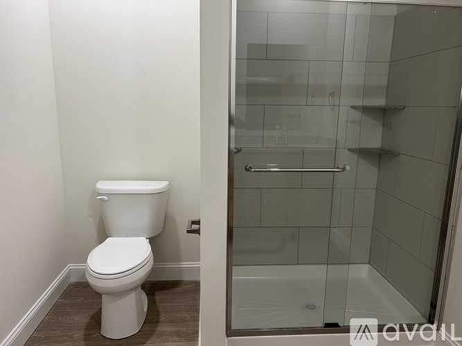 A white toilet in a bathroom with a glass shower door.