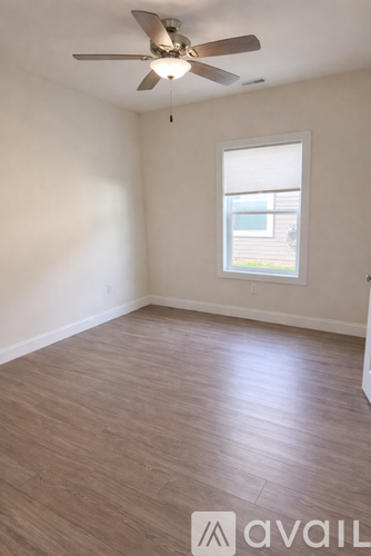 A room with a ceiling fan and a window.