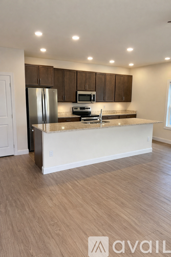 A kitchen with a refrigerator, microwave, and oven.