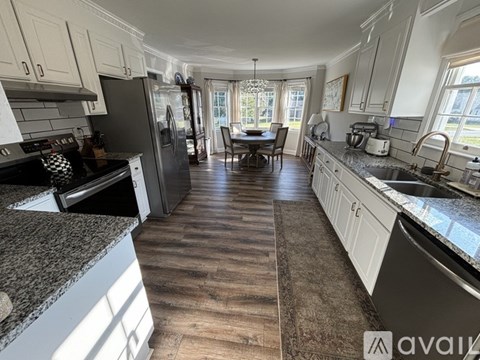 A kitchen with a dining table and chairs in the middle of the room.