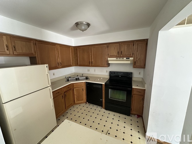 A kitchen with black appliances and wooden cabinets.