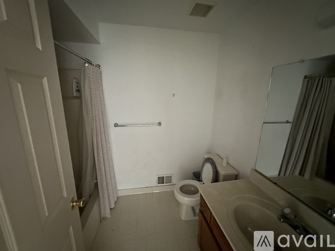 A bathroom with a toilet, sink, and shower.