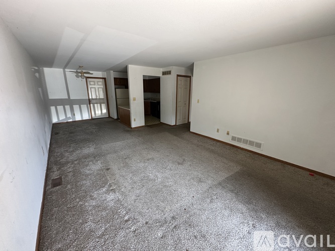 A spacious empty room with a fan and sliding doors.