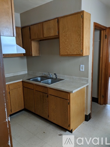 A kitchen with wooden cabinets and a sink.