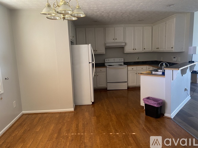 A kitchen with white cabinets and a white refrigerator.