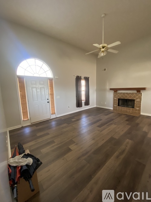 A room with a fireplace and a ceiling fan.