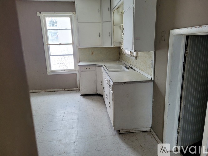A kitchen with white cabinets and appliances is available for rent.
