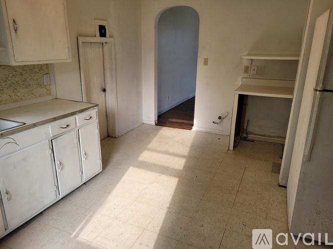 A kitchen with white cabinets and a tiled floor.