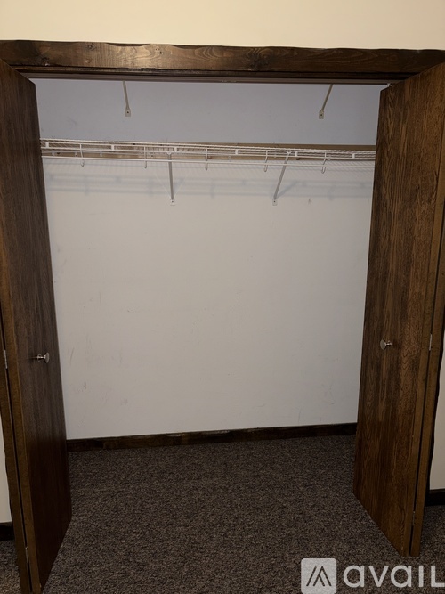 A room with a white wall and a brown door.