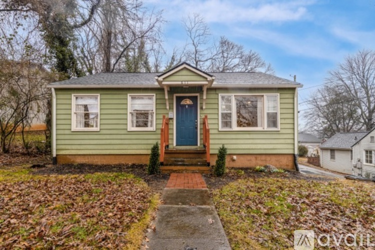 A green house with a blue door and a small front porch.