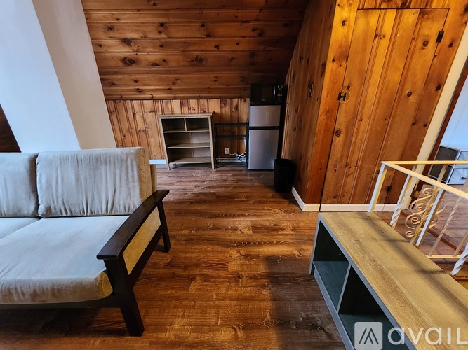 A living room with a couch and a wooden floor.